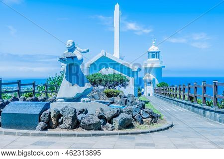 Udo Island, South Korea; June 22, 2022: Statue And Building In Front Of Udo Lighthouse On Sunny Day.