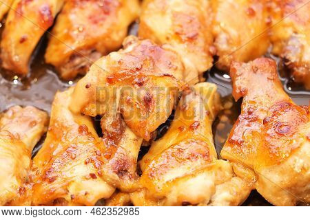 Backed Chicken Wings Parts With Garlic In Grill Skillet Close Up Food Photo. Fresh Roasted Poultry F