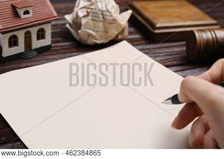 Woman Signing Last Will And Testament At Wooden Table, Closeup