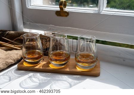 Flight Of Single Malt Scotch Whisky Served On Old Wooden Window Sill In Scottisch House In Edinburgh