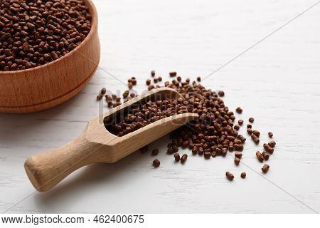 Scoop And Bowl With Buckwheat Tea Granules On White Wooden Table, Closeup