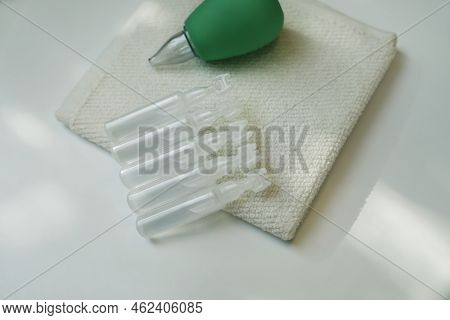 Single Dose Ampoules Of Sterile Isotonic Sea Water Solution, Towel And Nasal Aspirator On White Tabl
