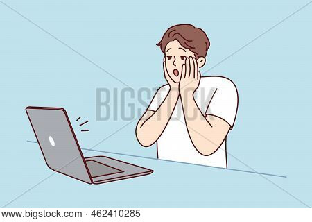 Stunned Young Man Look At Laptop Screen Shocked By Unexpected News Online. Amazed Male Surprised By 