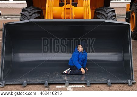 Minsk, Belarus, September 20, 2022: Child, Boy Posing Inside Bucket Of Excavator, Road Car Loader
