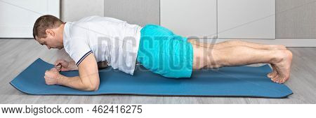 A Strong, Healthy Man With Muscles, Training At Home In The Plank Position. Fitness At Home. Banner.