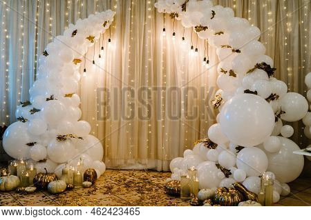 Decorated Arch For Wedding Ceremony. White Balloons, Candles, Autumn Leaves And Small Pumpkins. Autu