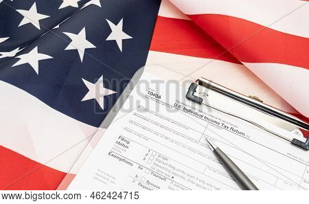 1040a Form On Clipboard And Usa Flag At Background