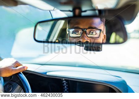 African American Man Sitting In A Car And Adjusting Rearview Mirror Looking To Back