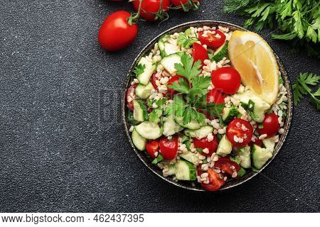 Bulgur Tabbouleh Salad With Fresh Tomatoes, Cucumbers, Parsley And Lemon Dressing. Traditional Middl
