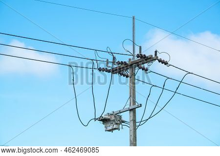 Electric Pole And Electric Transformer On Beautiful Blue Sky Background.