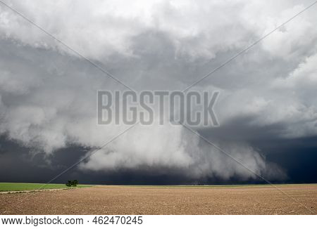 Light Shines On A Thick Shelf Cloud Hanging Low To The Ground Under A Severe Storm