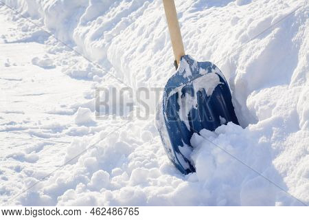 Cleaning Snow After A Snowstorm In Winter. Snow Shovel Near A Big Snowdrift Before Removing Snow In 