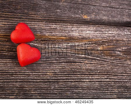 Due caramelle di cuore amore di crack rompere sfondo texture legno, giorno di San Valentino cartolina concetto