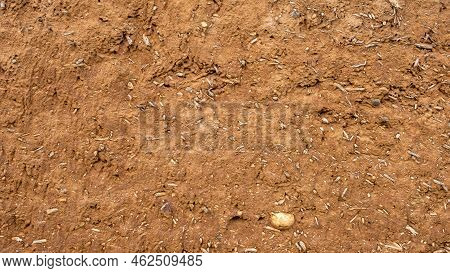 Close-up Background Of The Wall Of An Old House Made Of Clay Mixed With Straw. Old Type Of Construct