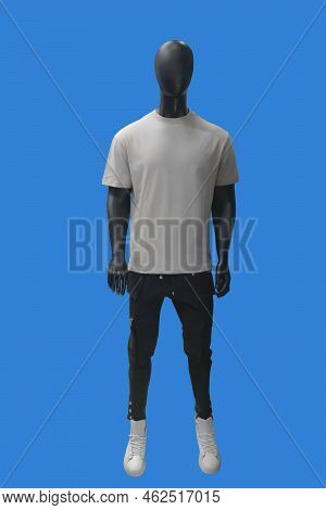 Full Length Image Of A Male Display Mannequin Wearing White T-shirt And Black Cargo Pants Isolated O