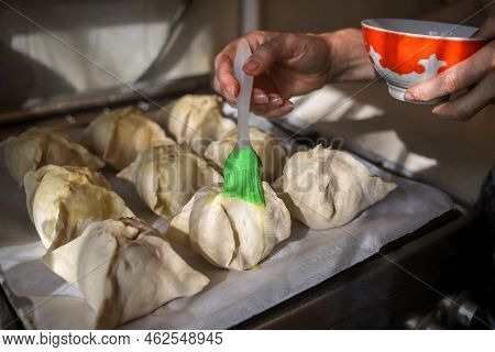 Making Apples Baked In Dough. Closeup Of Woman's Hands Spreading Egg Yolk With Silicone Culinary Bru