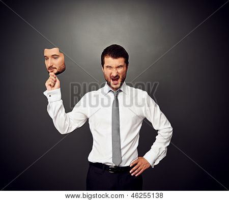 rozhněvaný muž, který držel masku s klidnou náladu