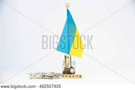 Donation For Ukraine Concept. Donation Jar With Coins, Dollars And Ukrainian Flag