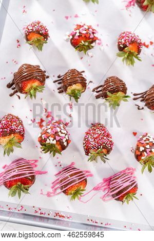Decorating Chocolate-covered Strawberries With Chocolate Drizzles And Sprinkles.