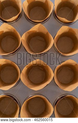 Scooping Dough Into The Cupcake Pan Lined With Parchment Muffin Liners To Bake Sharlotka Muffins.
