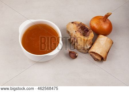 Homemade Boiled Beef Bone Broth In White Bowl On Stone Table. Selective Focus, Copy Space. Golden Me