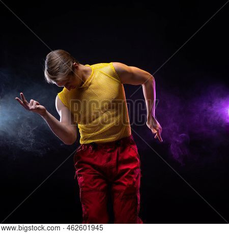 A Young Muscular Man In A Bright Outfit Poses In A Pretentious Pose, Style And Grotesque. Attractive