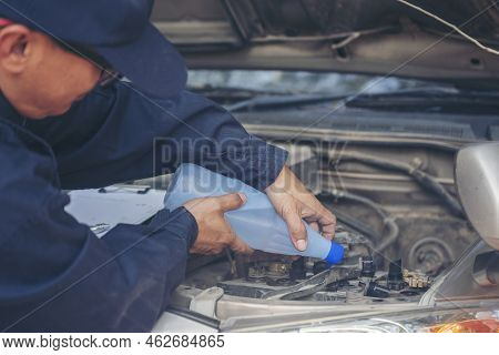 Car Mechanic Man Hands Pouring Deionized Purified Distilled Water For Car Battery Mechanical Service