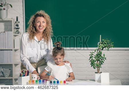School Girl Drawing With Teacher. Children From Elementary School Study At Draw Lesson. Pupil Girl W