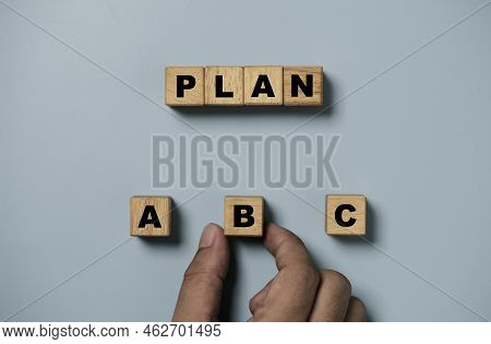 Hand Holding B Wording On Wooden Cube Block For Backup Plan Selection Of Business Planing Concept.