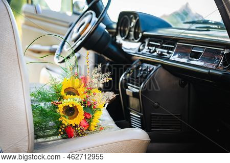 Vintage Wedding Car With Lovely Wedding Bouquet Full Of Roses And Sunflowers