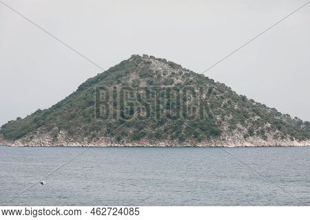 Small Greek Island Covered With Small Vegetation During A Sunny Summer Day.