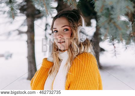 Teen Blonde In A Yellow Sweater Outside In Winter. A Teenage Girl On A Walk In Winter Clothes In A S