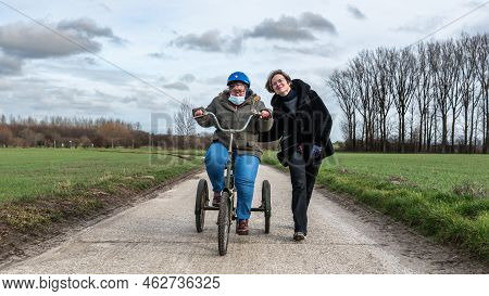 Crying Girl With Down Syndrome Driving The Tricycle In The Flanders Fields, Hakendover, Belgium