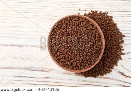Bowl With Buckwheat Tea Granules On White Wooden Table, Top View. Space For Text