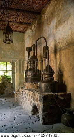 Closeup Of An Authentic Antique Copper Home Distiller, In Old Building, On Stone, Patina On Walls An