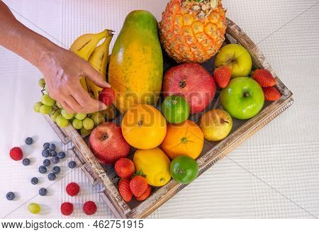 Wooden Basket Full Of Fresh Fruit On A White Background. Citrus Fruits, Papaya, Pineapple, Banana, P