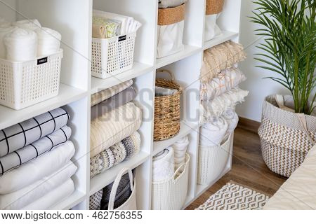 Neatly Folded Linen Cupboard Shelves Storage At Eco Friendly Straw Basket Placed Closet Organizer