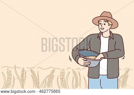 Male Farmer Working In Field On Harvest Season. Smiling Man Busy With Agriculture On Pasture Or Crop