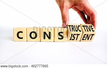 Constructive Or Consistent Symbol. Businessman Turns Cubes, Changes The Word Consistent To Construct