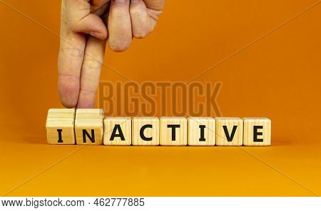 Active Or Inactive Symbol. Businessman Turns Wooden Cubes And Changes The Word Inactive To Active. B