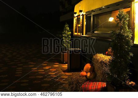 Halloween Background With Texture Orange Pumpkins On Dark Strow Stack Near Coffee Trailer Stall. Clo