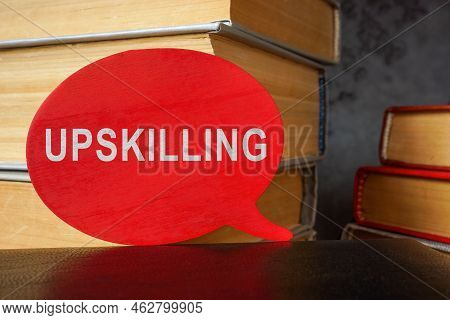 Stack Of Books And Plate With Word Upskilling.