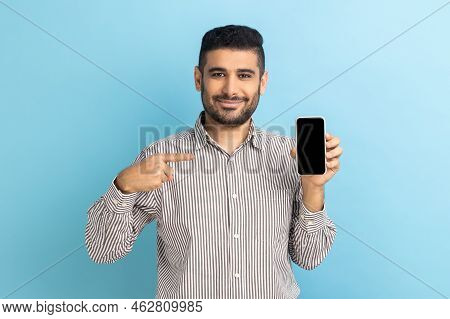 Cheerful Beaded Businessman Pointing Finger At Smartphone With Empty Screen, Looking At Camera With 