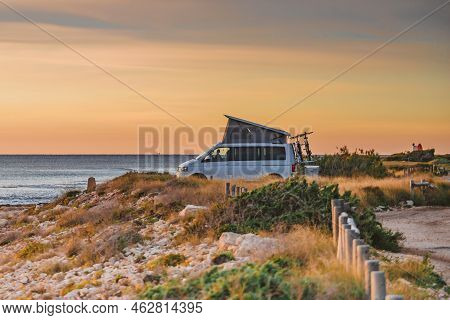 Van Camper With Roof Top Tent Camping On Mediterranean Coast. Holidays And Travel In Mobile Home. Va