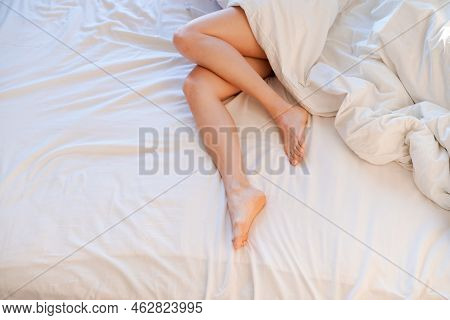 Slim, Perfect And Beautiful Crossed Womans Legs On Bed. Cropped Image Erotic Woman Lying On The Bed 