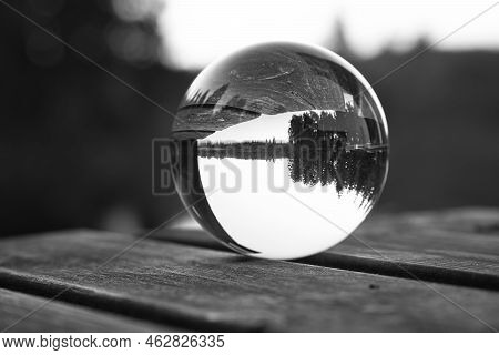 Glass Ball On A Wooden Pier At A Swedish Lake At Dusk In Black And White. Nature Shot From Scandinav