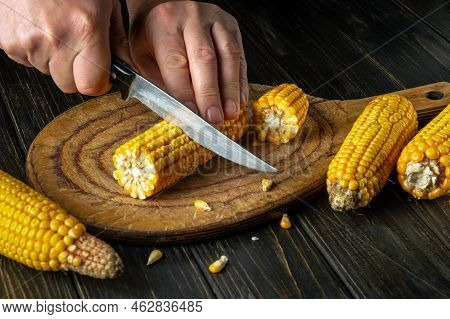 Cook Cuts The Grains Of Corn With A Knife. Maize Is An Excellent Dietary Breakfast Or Lunch By The H