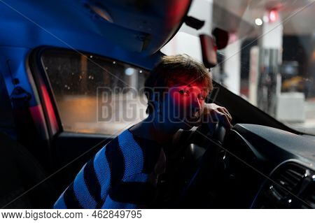 Tired Caucasian Woman Sits Behind Wheel With Head Resting On Steering Waiting For Fellow Traveler. G