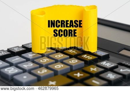 Business Concept. On The Calculator Is A Yellow, Twisted Paper Plate With The Inscription - Increase