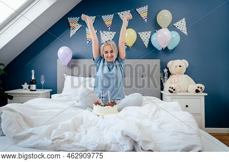 Happy Emotional Woman In Pajama And Party Cap After Blowing Out The Candles On Birthday Cake, Sittin